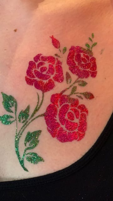 Glittery temporary tattoo of roses on skin.