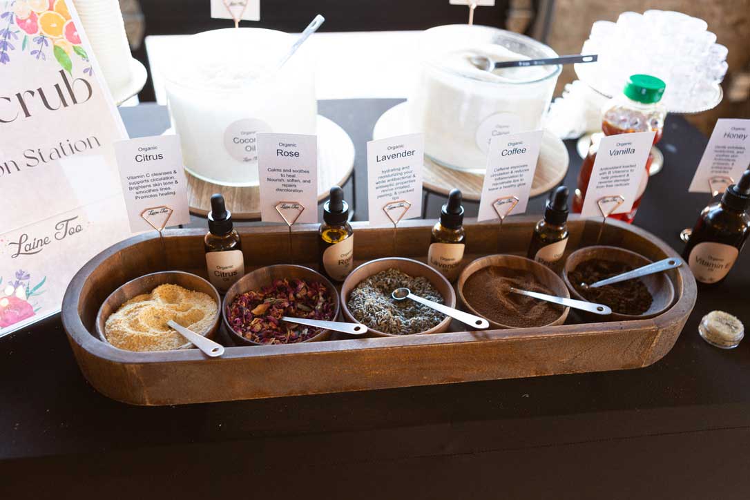A variety of scented ingredients displayed for customizing sugar scrubs at a diy station.