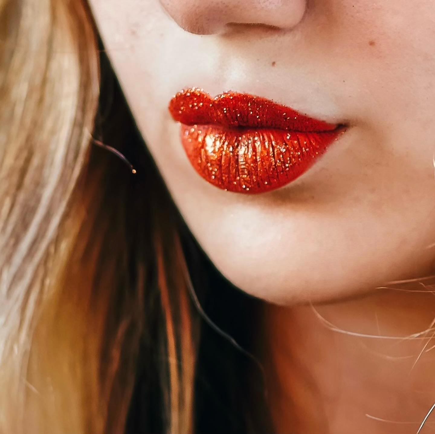 Close-up of a person with glittery red lipstick.