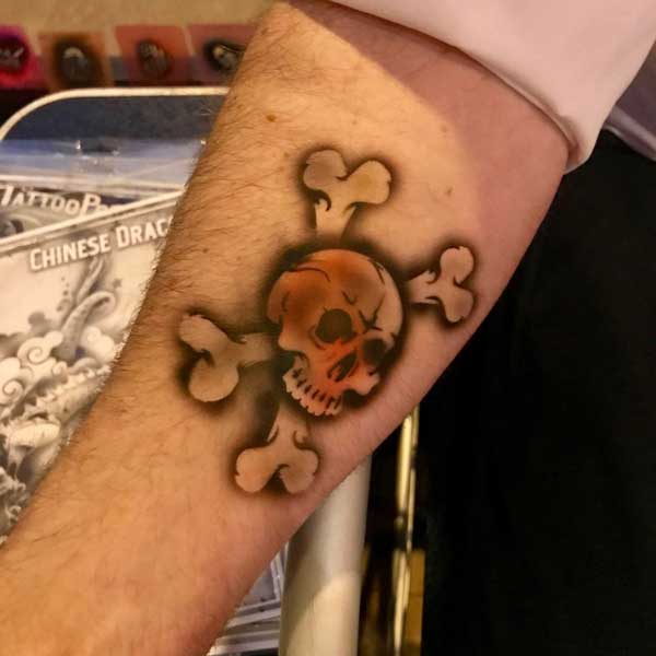 A tattoo of a skull with puzzle pieces on a person's forearm.