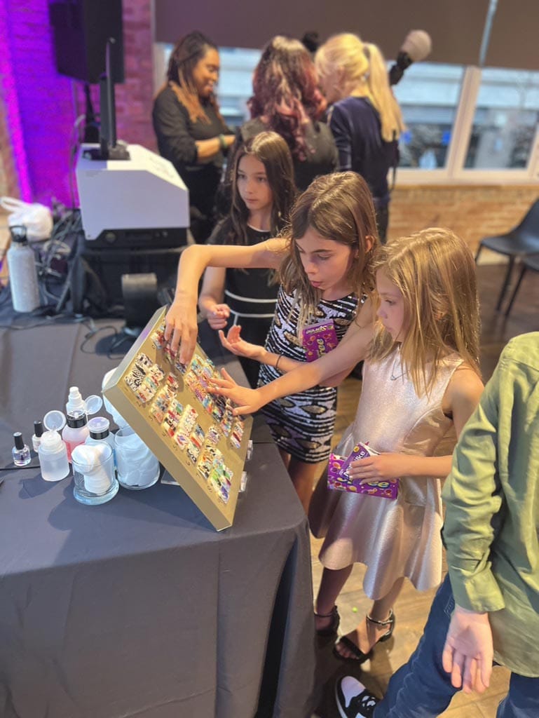 Children looking at a board with pictures at an indoor event.