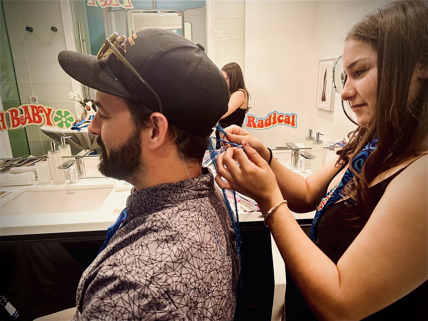 Woman trimming a man's hair in a salon.