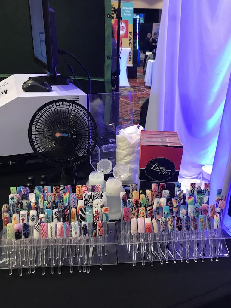 An assortment of colorful nail art designs displayed at a beauty or trade event.