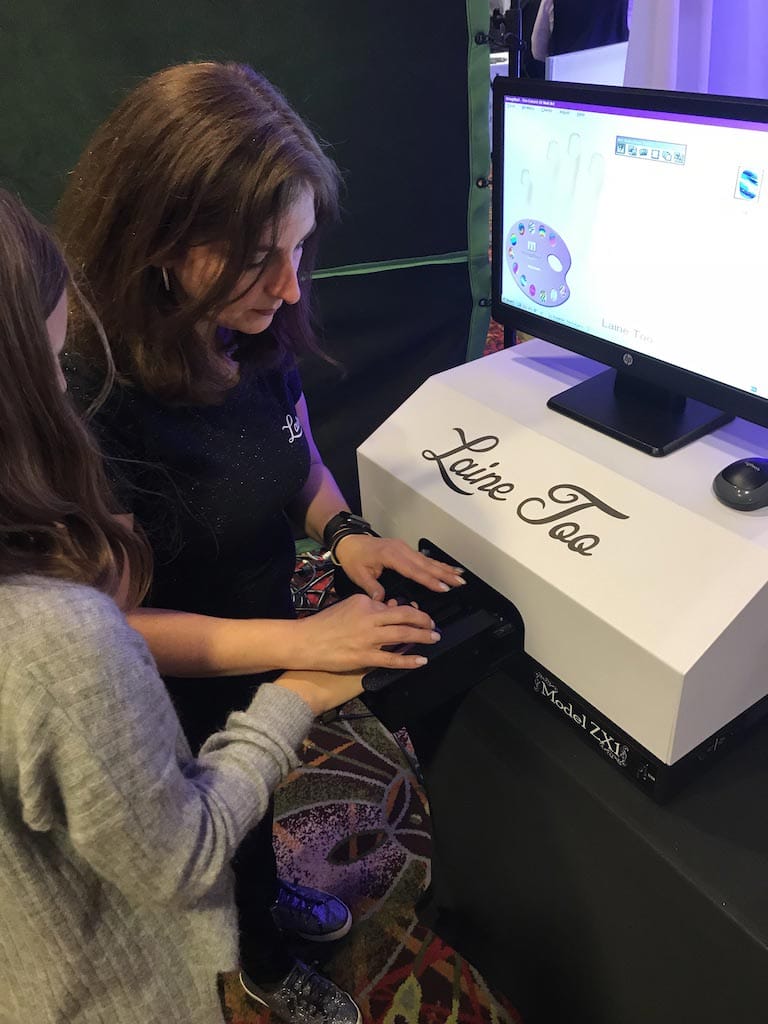 Two individuals examining a tabletop interactive display at an event.