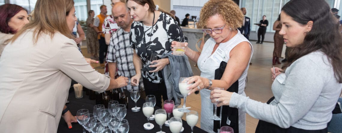 A group of attendees at a networking event participate in experiential branding by making their own candles.